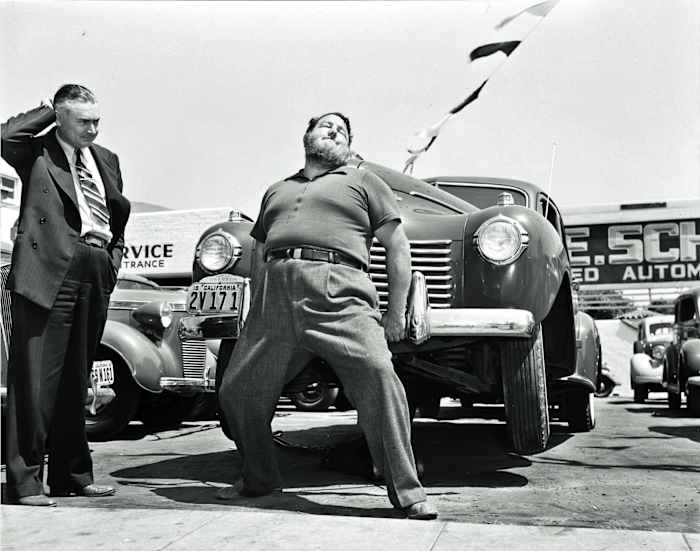 Leavitt lifting a car in an L.A. sales lot.